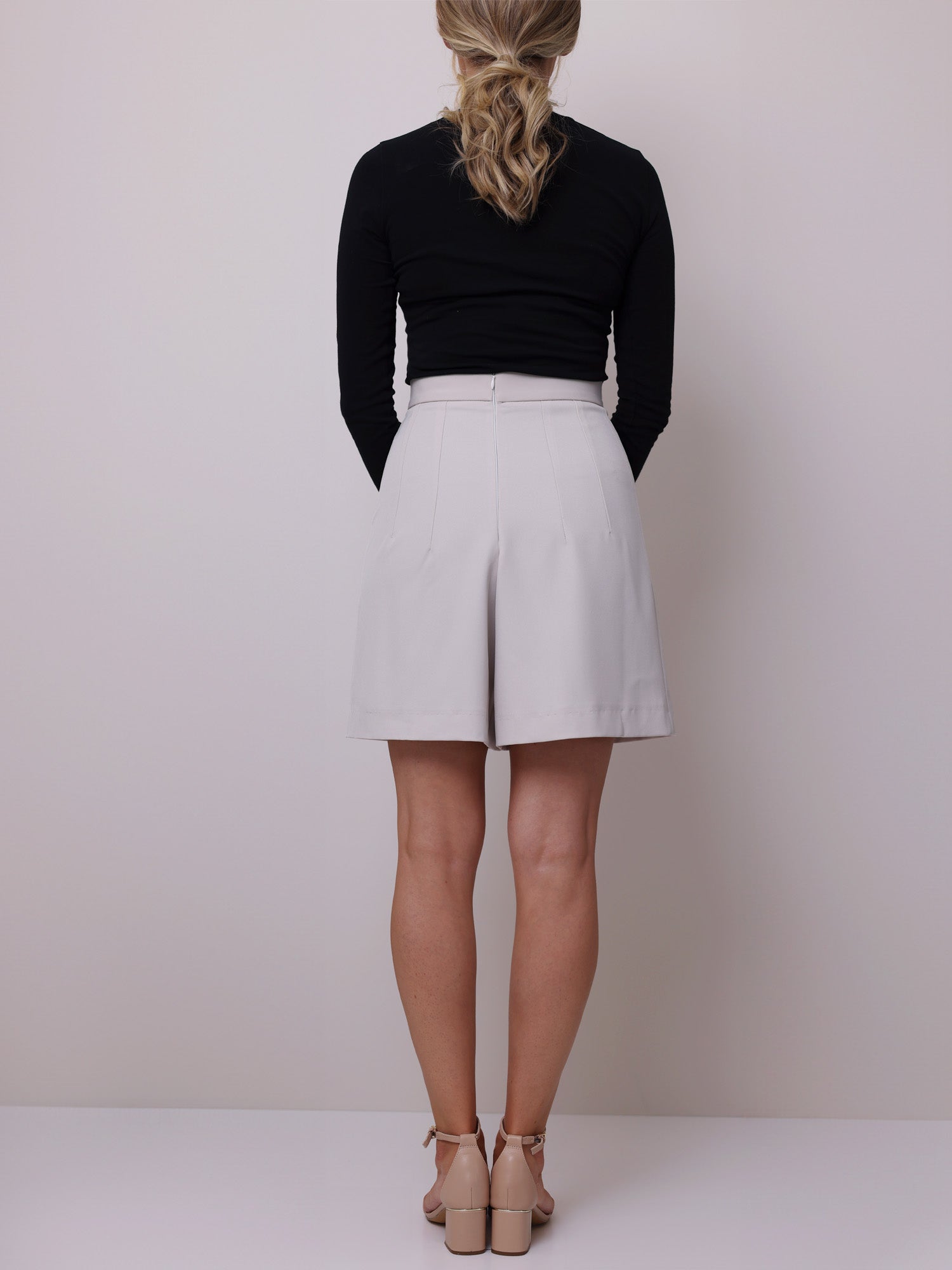 Back view of high-waisted shorts that looks like a skirt, with a wide waistband and a structured fit.