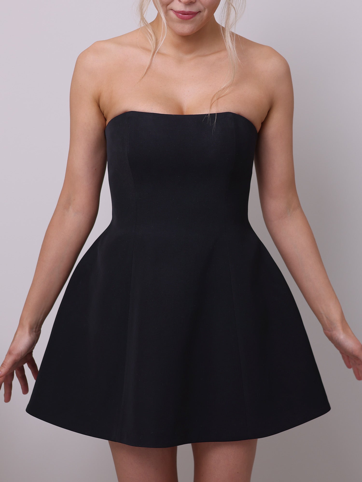 Front view of a strapless corset dress sewing pattern with an hourglass silhouette, boned bodice, and flared mini skirt in elegant black fabric.
