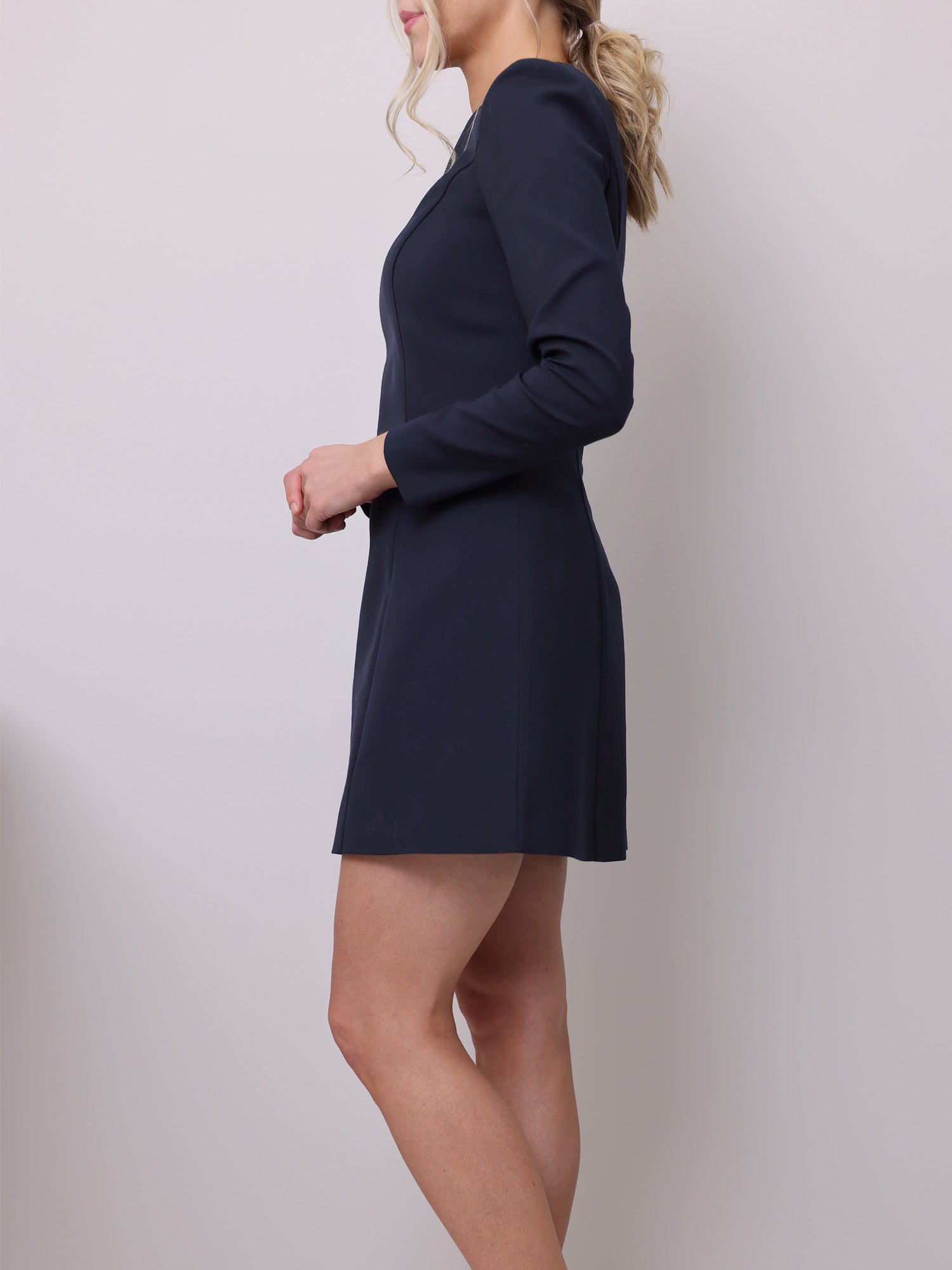 Side view of the mini dress sewing pattern with long sleeves shoulder pads and a fitted waist.